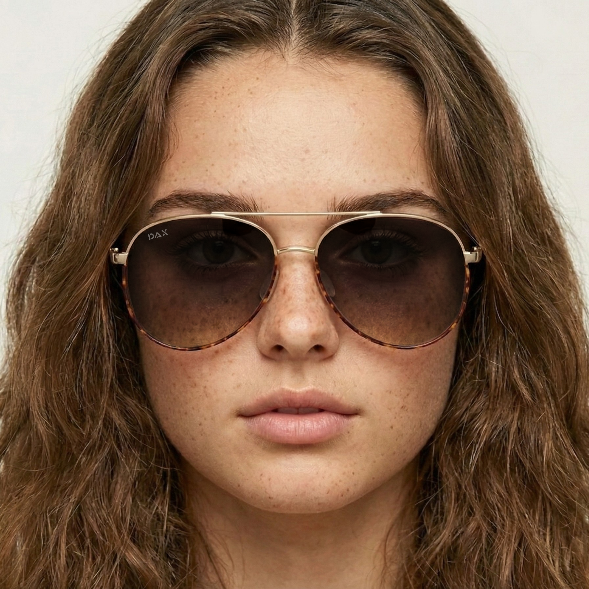 Close-up of a person wearing sunglasses with a neutral background