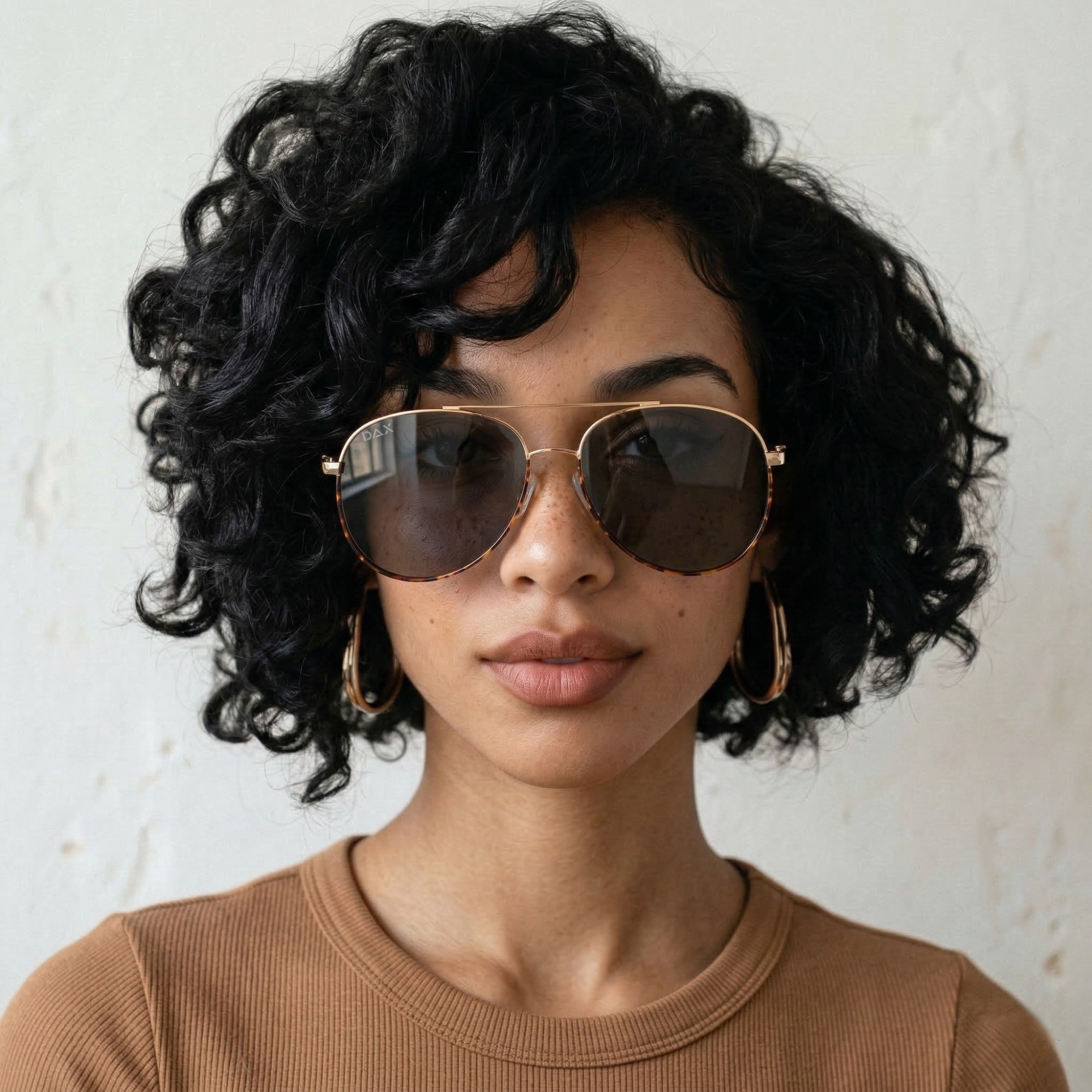 Woman wearing sunglasses with a neutral background