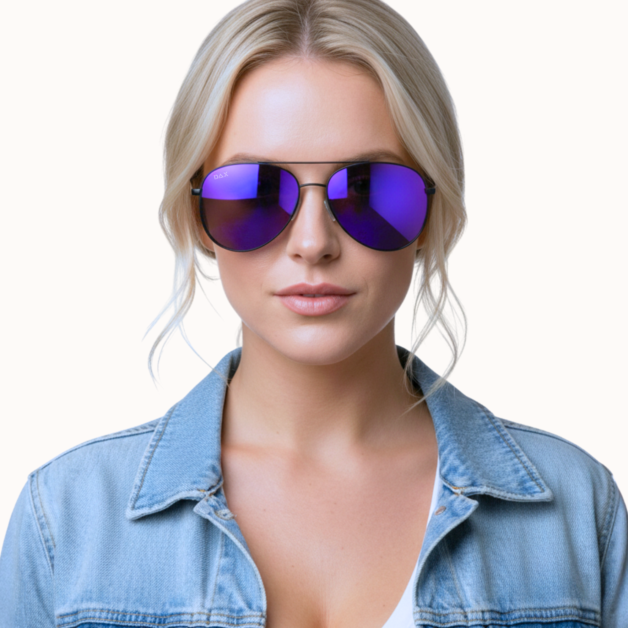 Woman wearing purple reflective sunglasses and a denim jacket on a white background