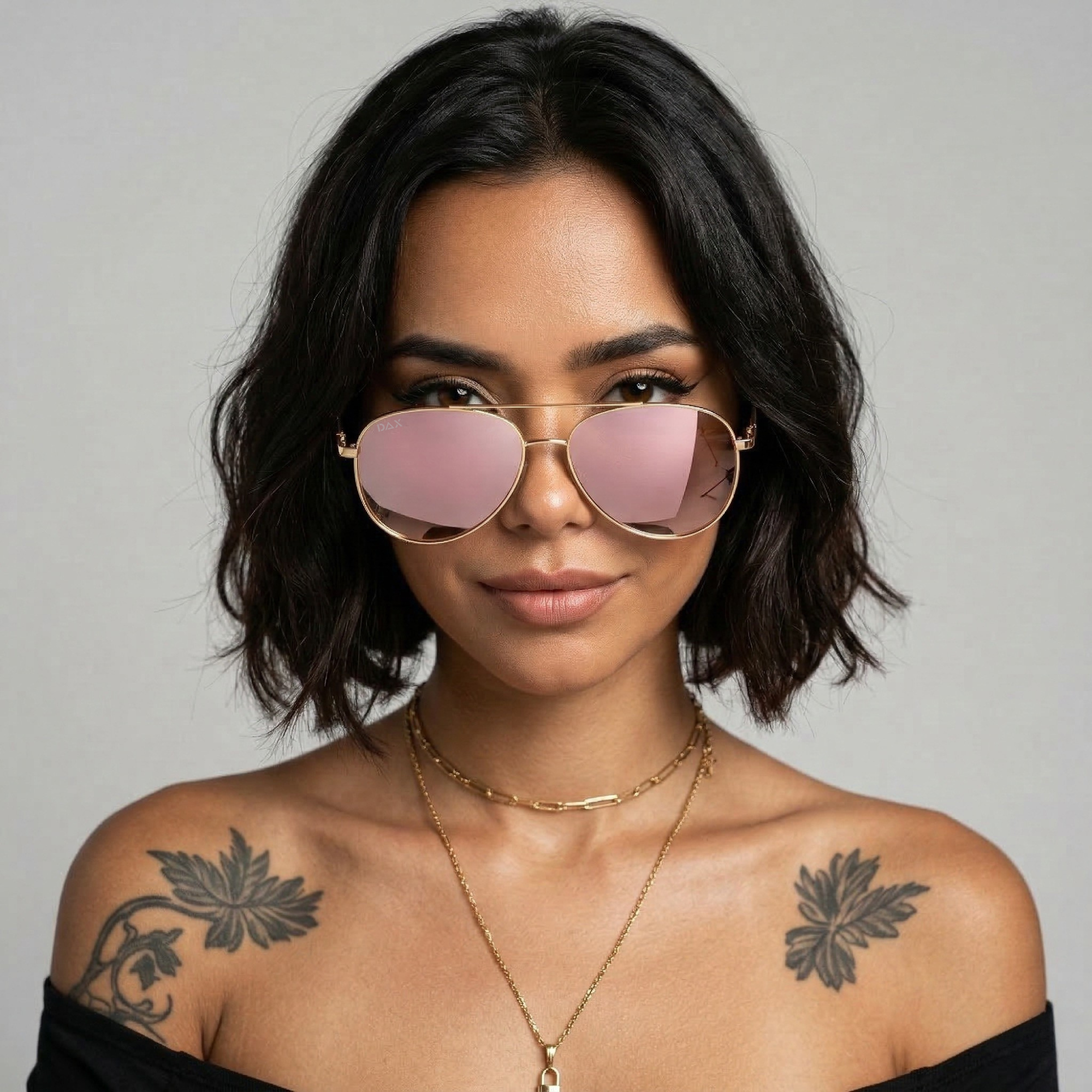 Woman wearing rose gold aviators against a neutral background.