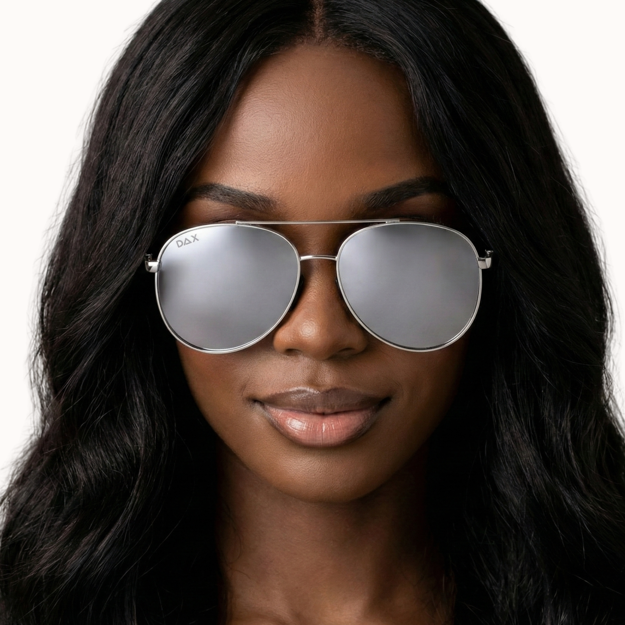 Woman wearing silver aviator sunglasses with a plain background