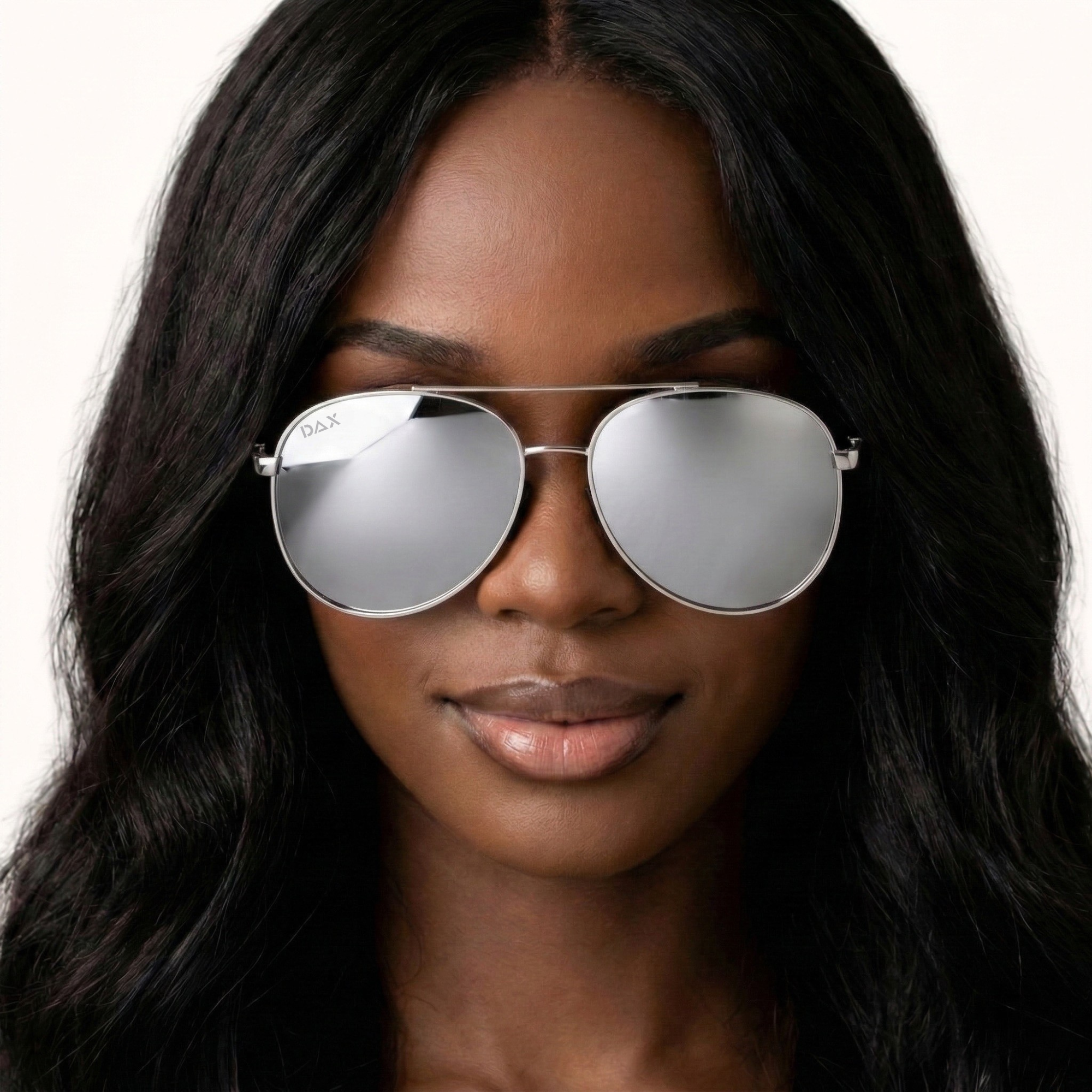 Woman wearing silver aviator sunglasses with a plain background