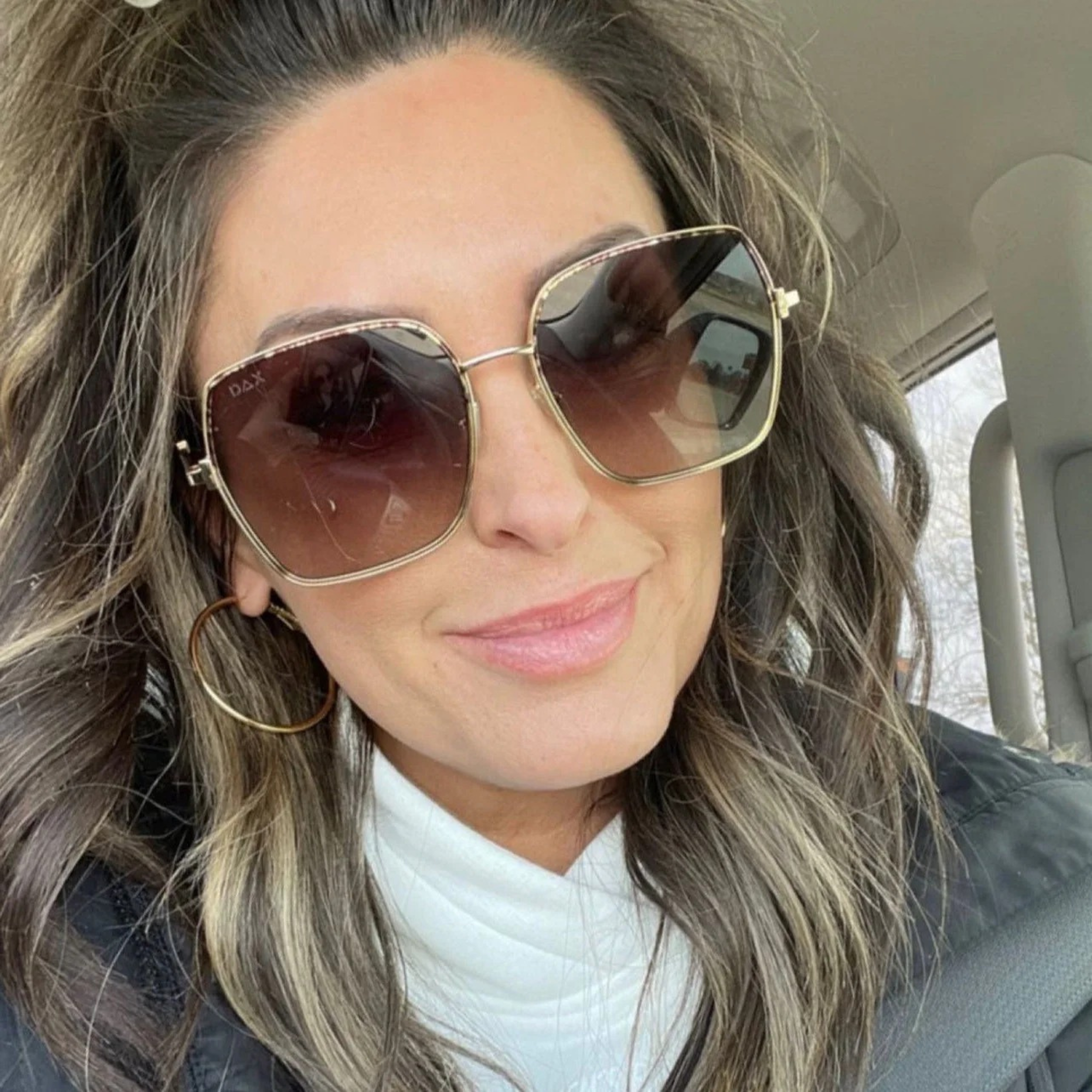 Woman wearing sunglasses inside a vehicle