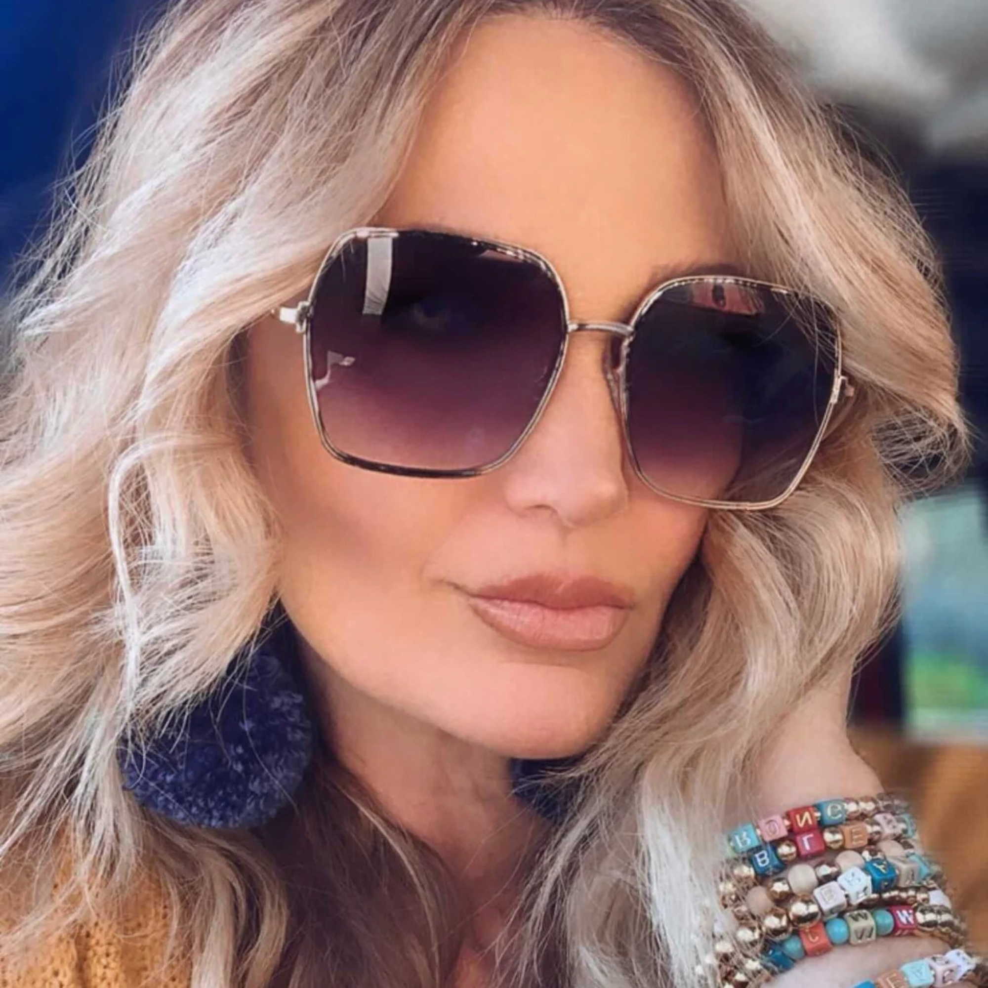 Woman wearing large sunglasses with a blurred background