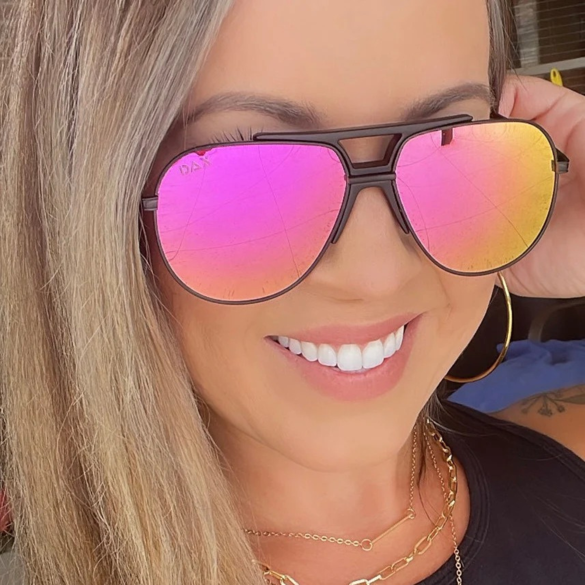Person wearing sunglasses with pink and yellow gradient lenses