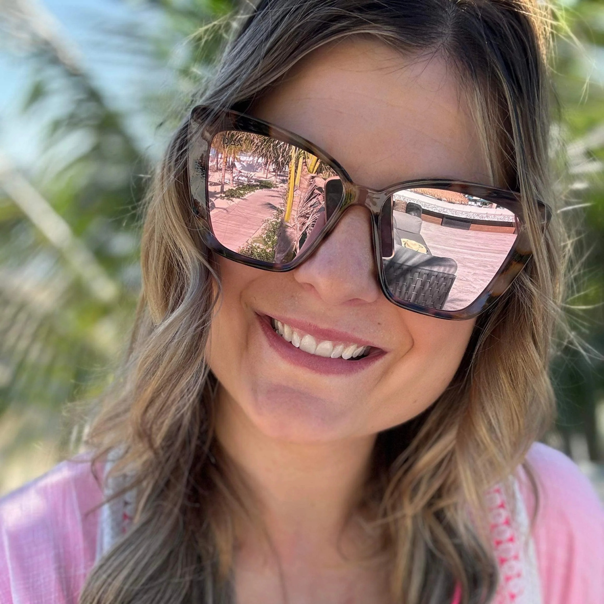 Woman wearing sunglasses with a blurred outdoor background