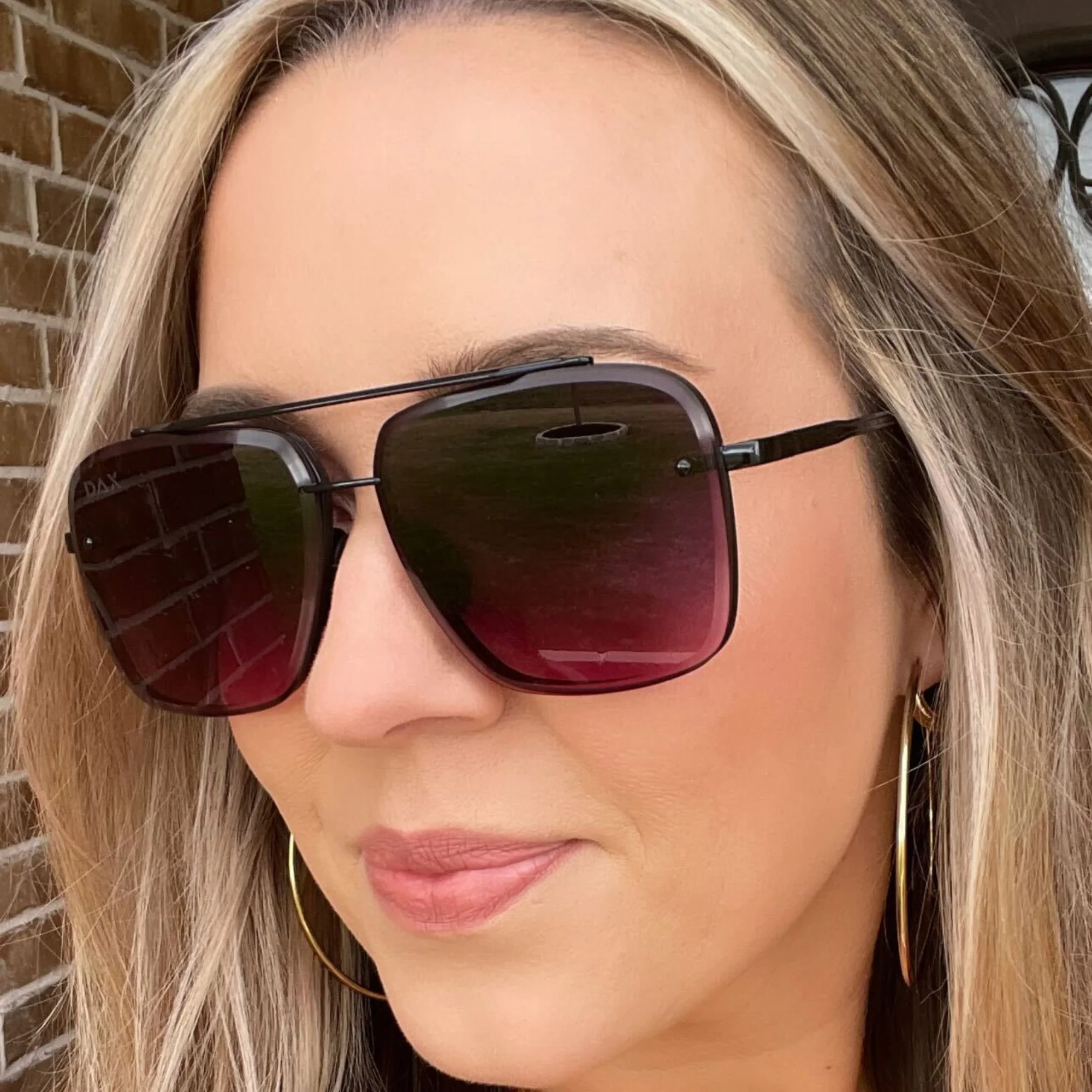 Close-up of a woman wearing dark sunglasses with a blurred background