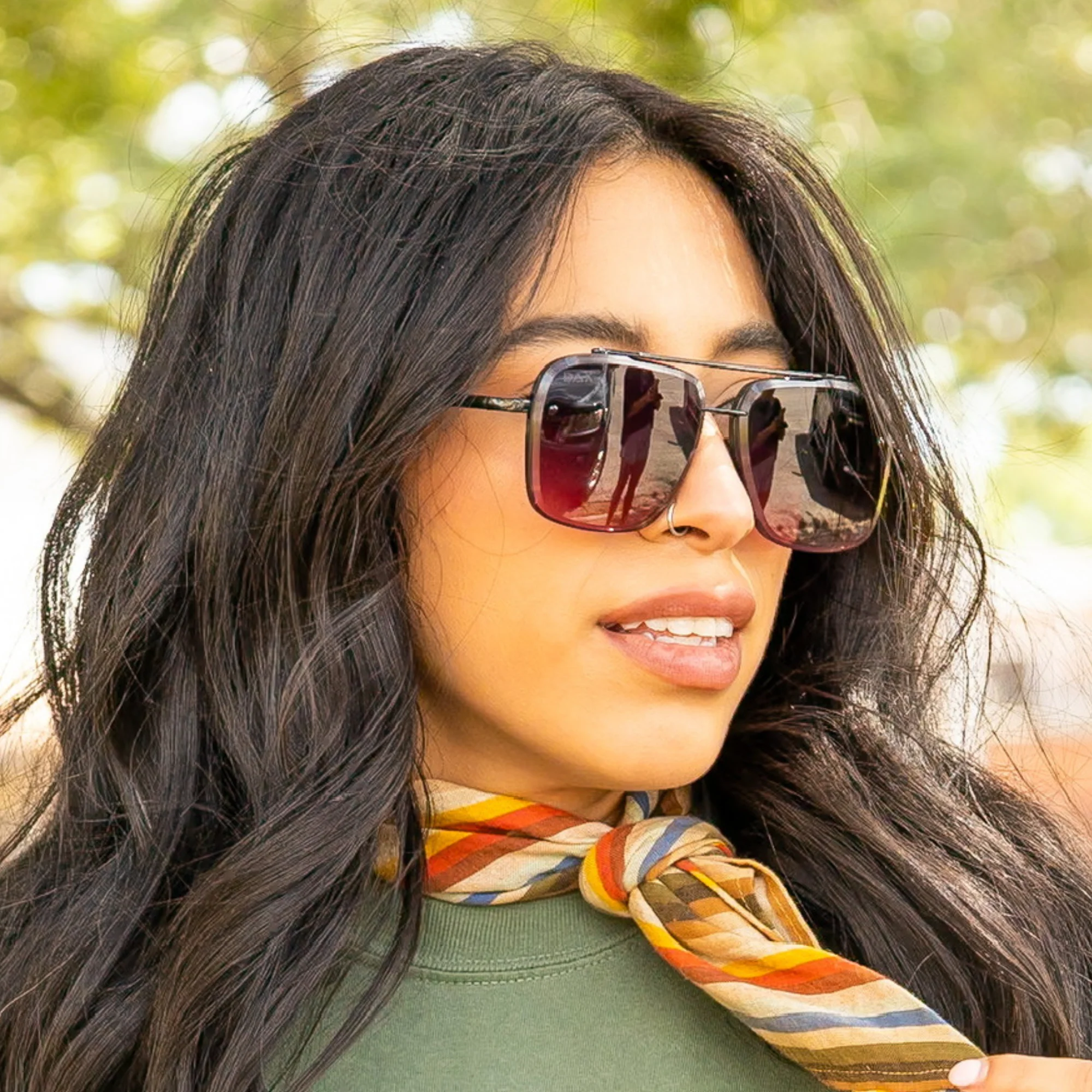 Woman wearing sunglasses with a blurred natural background