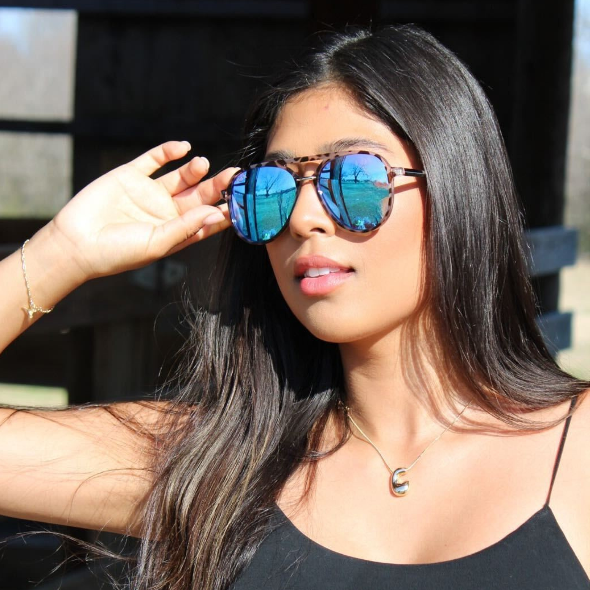 Woman wearing reflective sunglasses outdoors