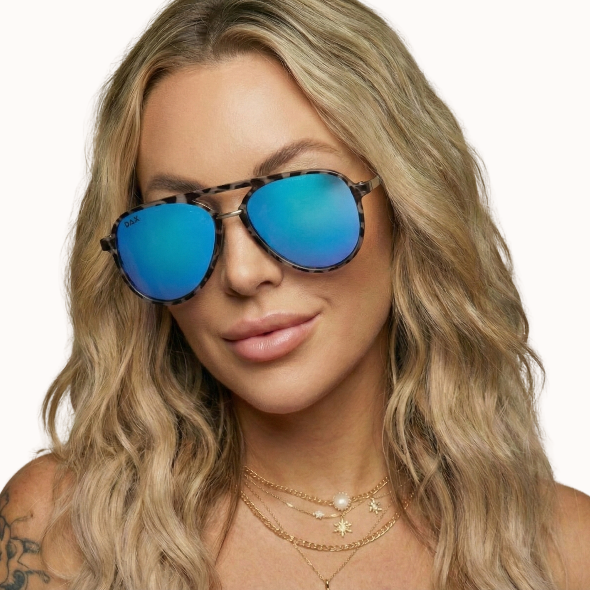Woman wearing blue reflective sunglasses with a neutral background