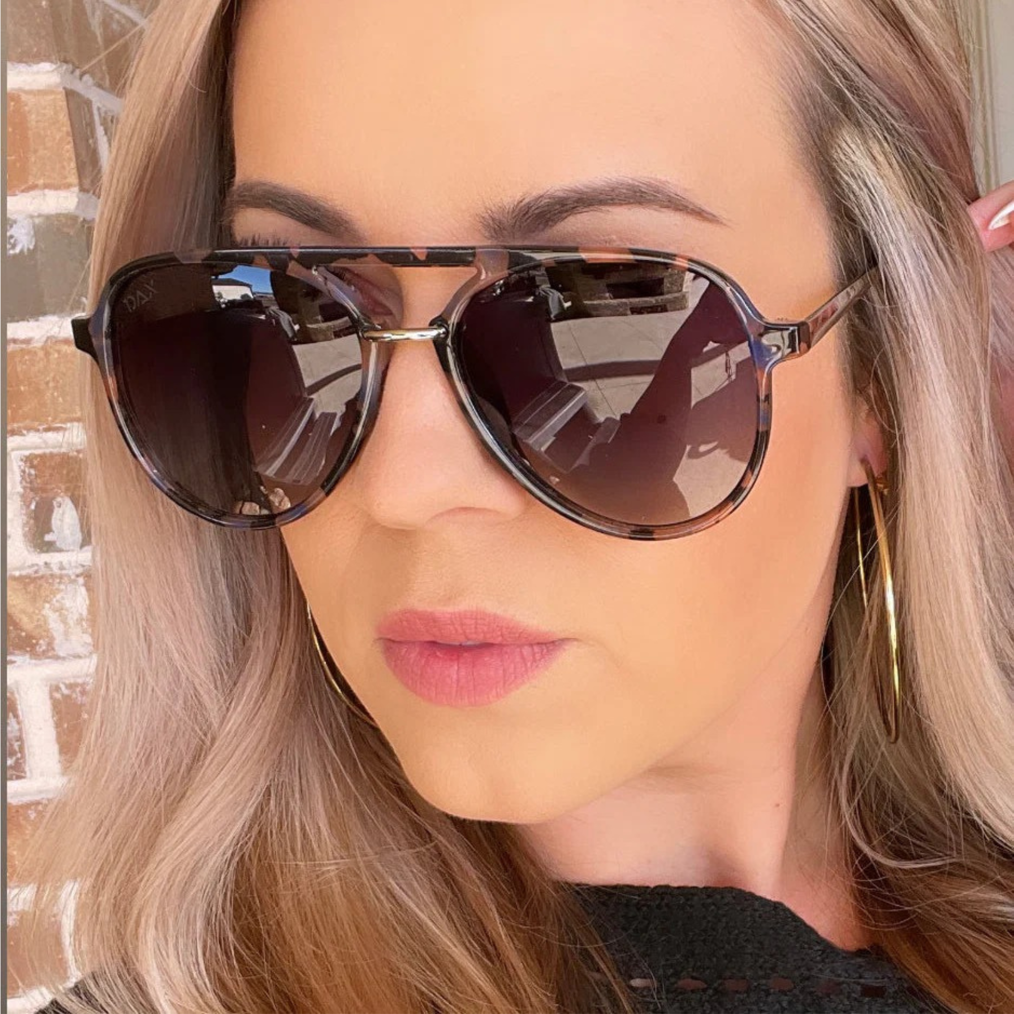 Close-up of a person wearing sunglasses with a blurred background