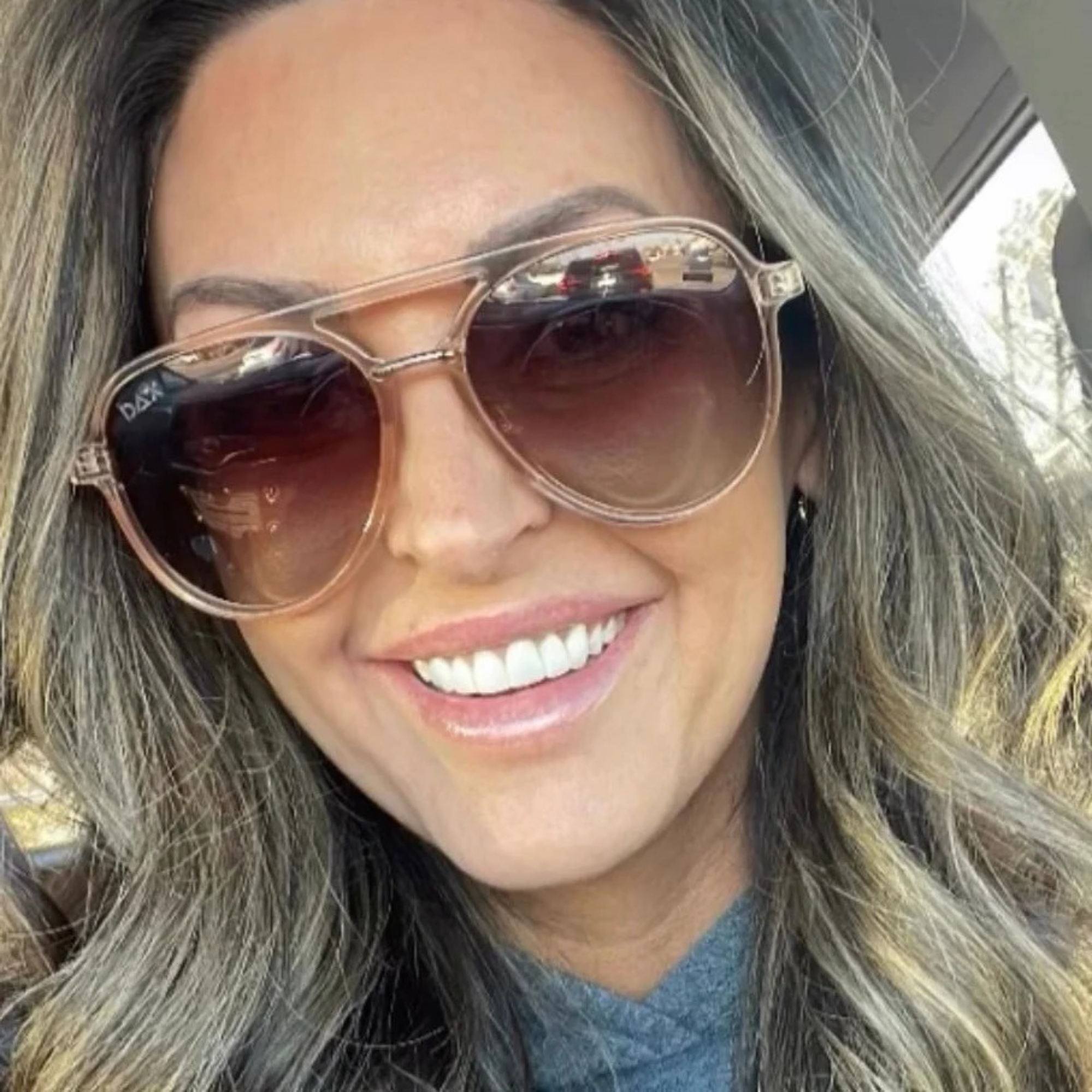 Woman wearing sunglasses with a blurred outdoor background