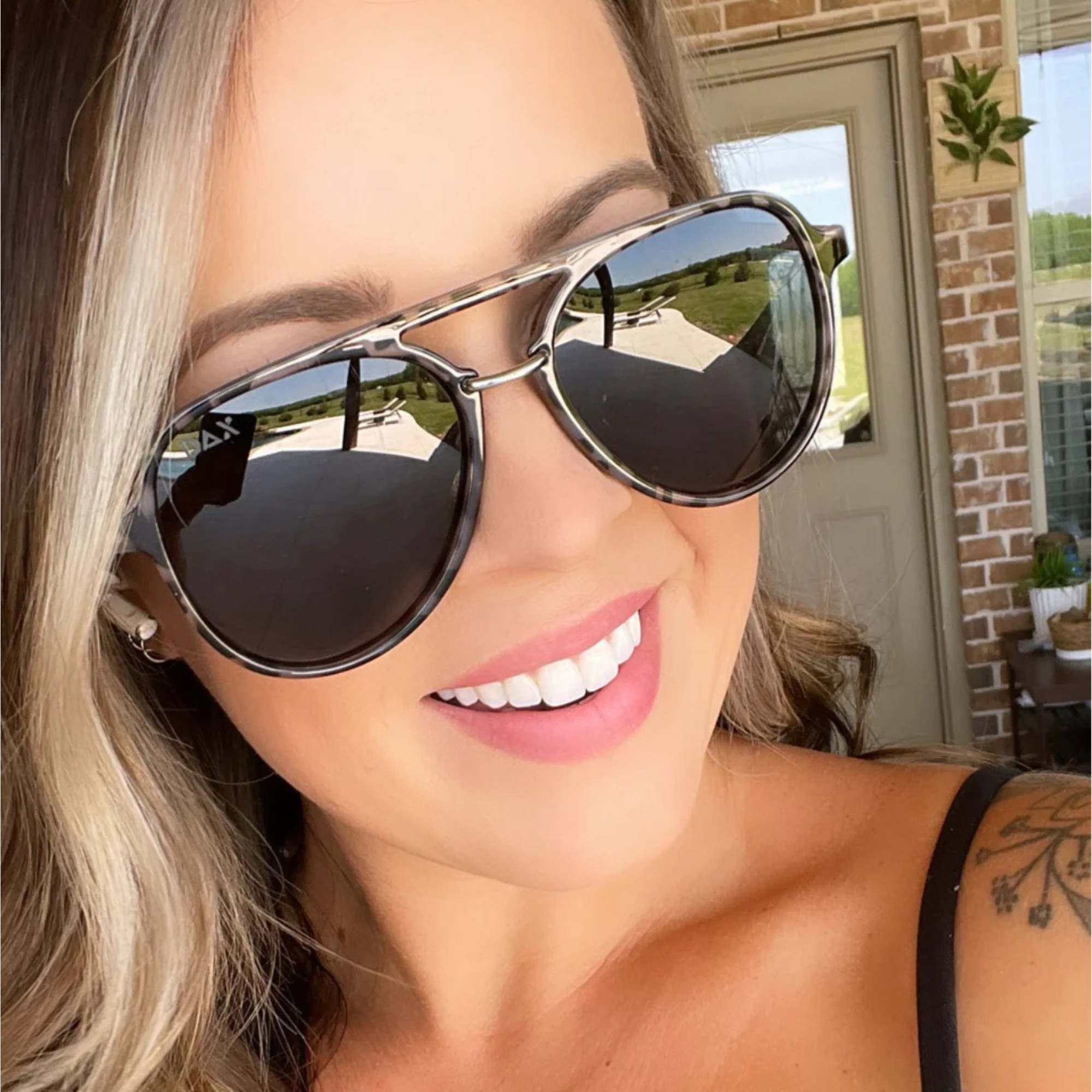 Woman wearing large sunglasses with a blurred background