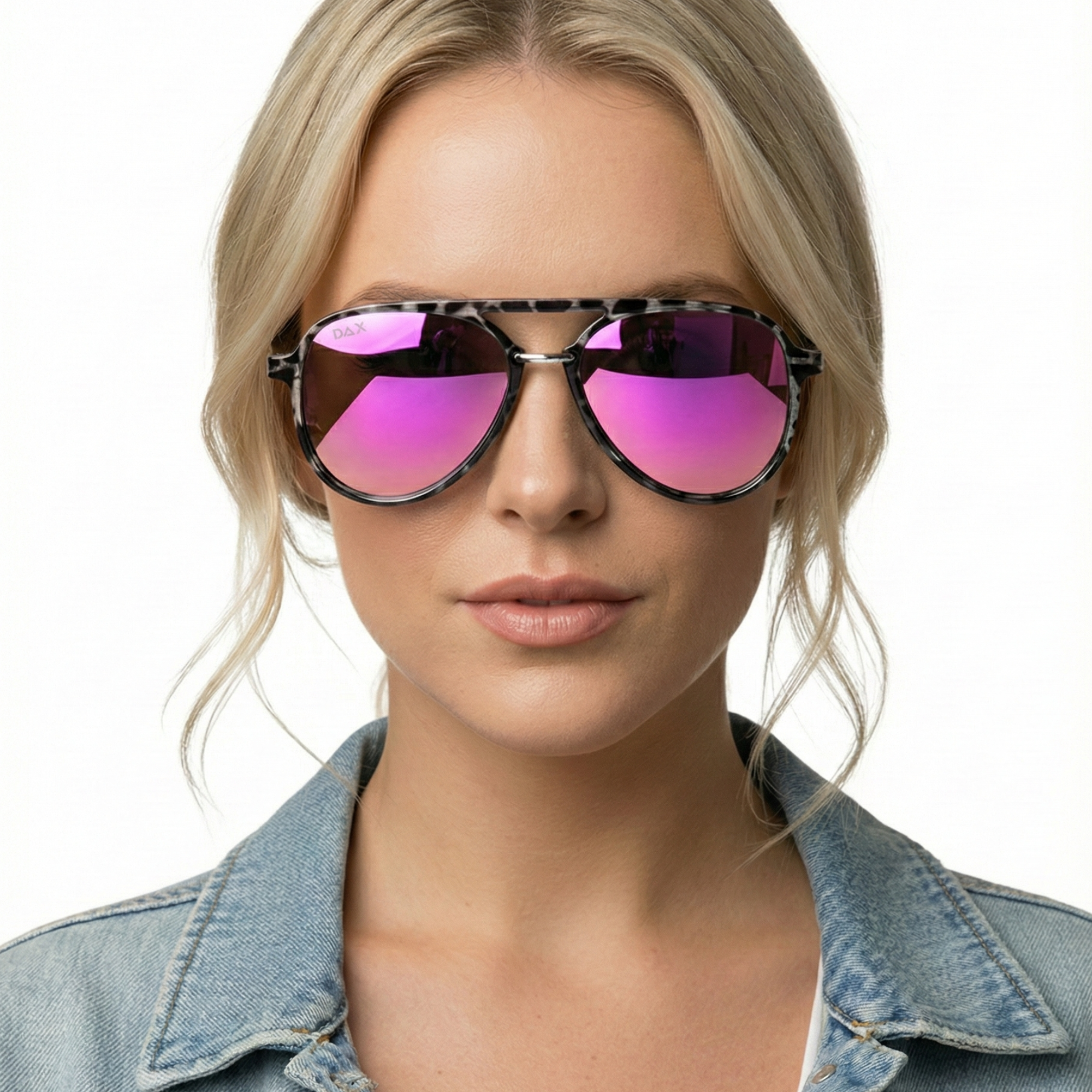 Woman wearing pink-tinted sunglasses with a denim jacket on a white background