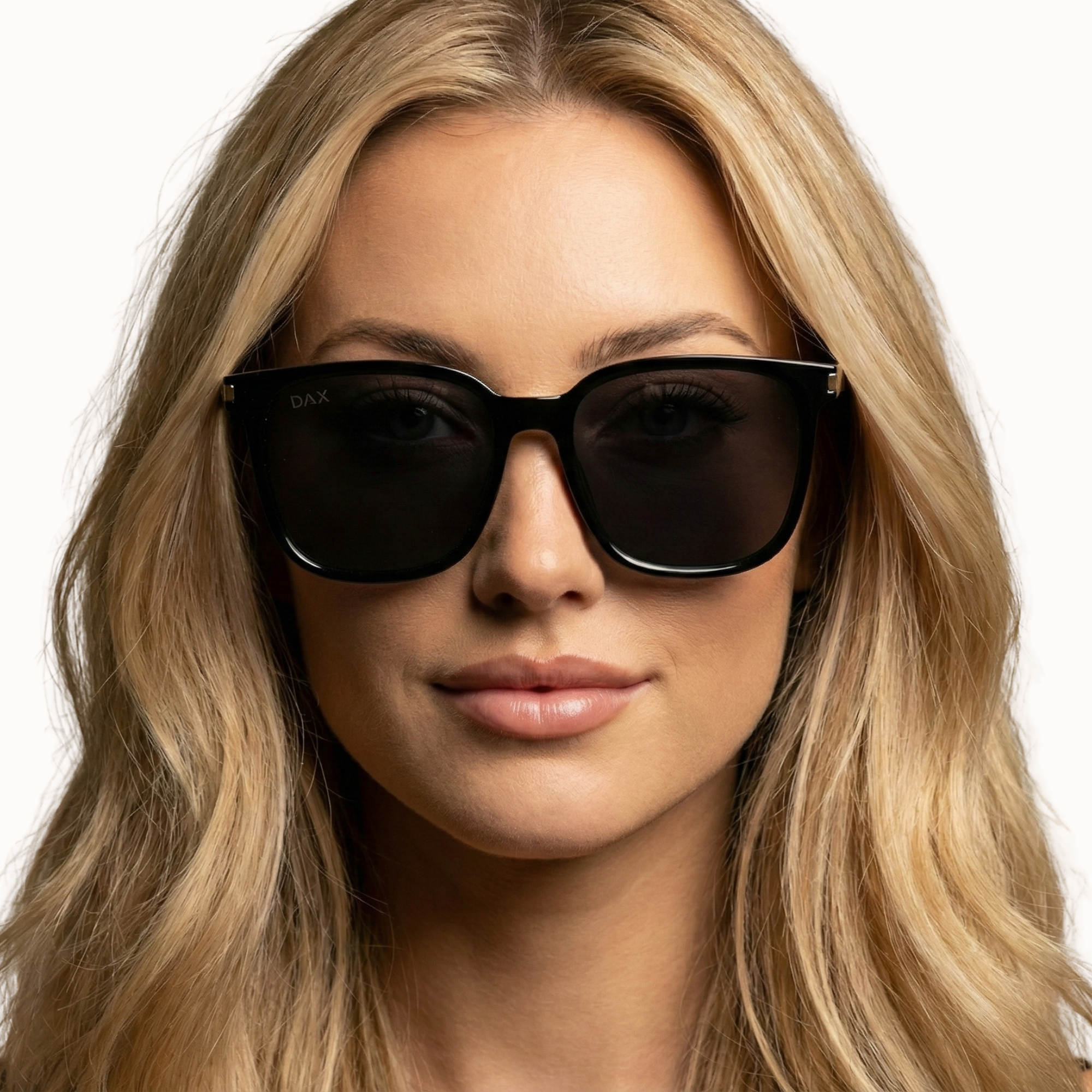 Woman wearing dark sunglasses with a neutral background