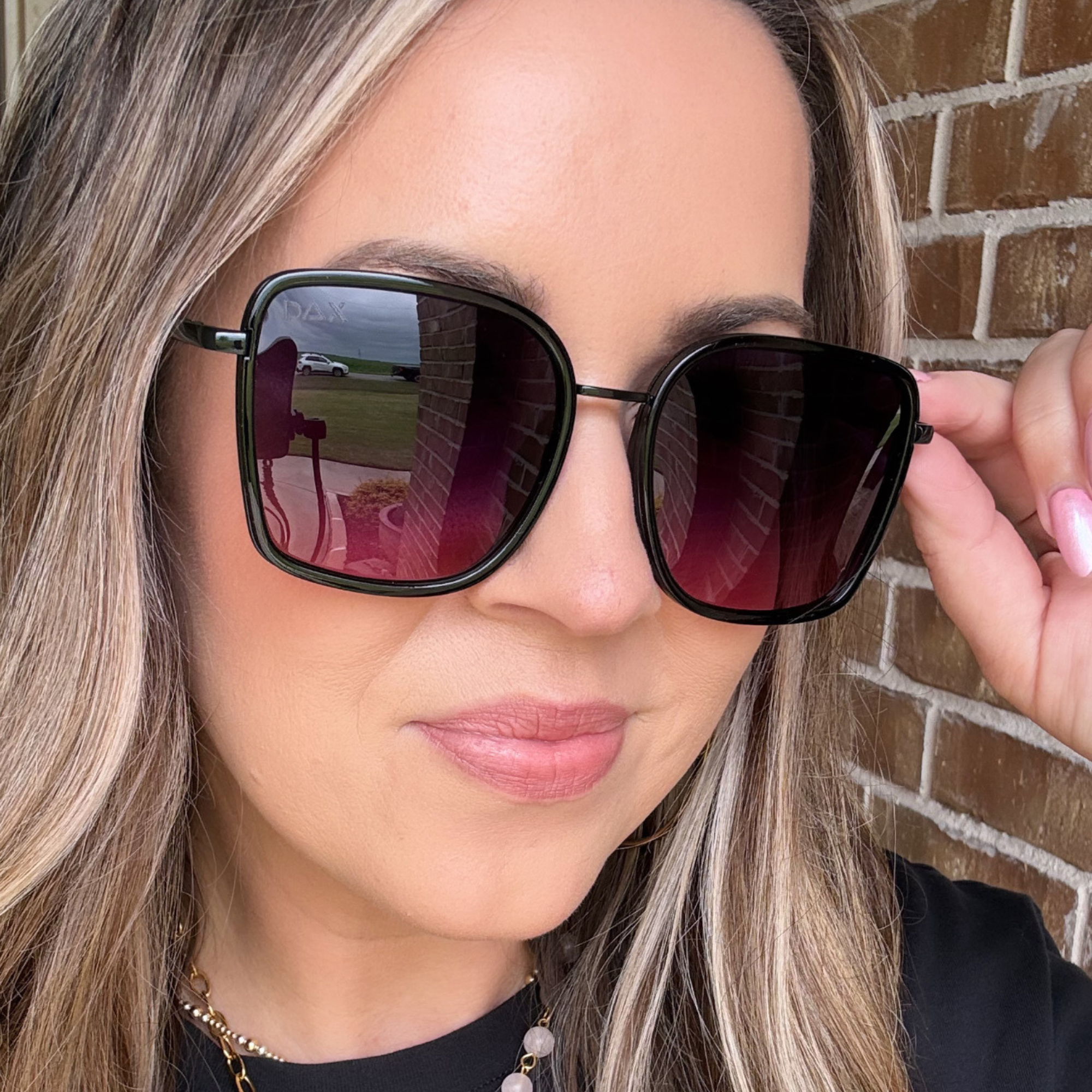 Woman wearing black sunglasses with a blurred background