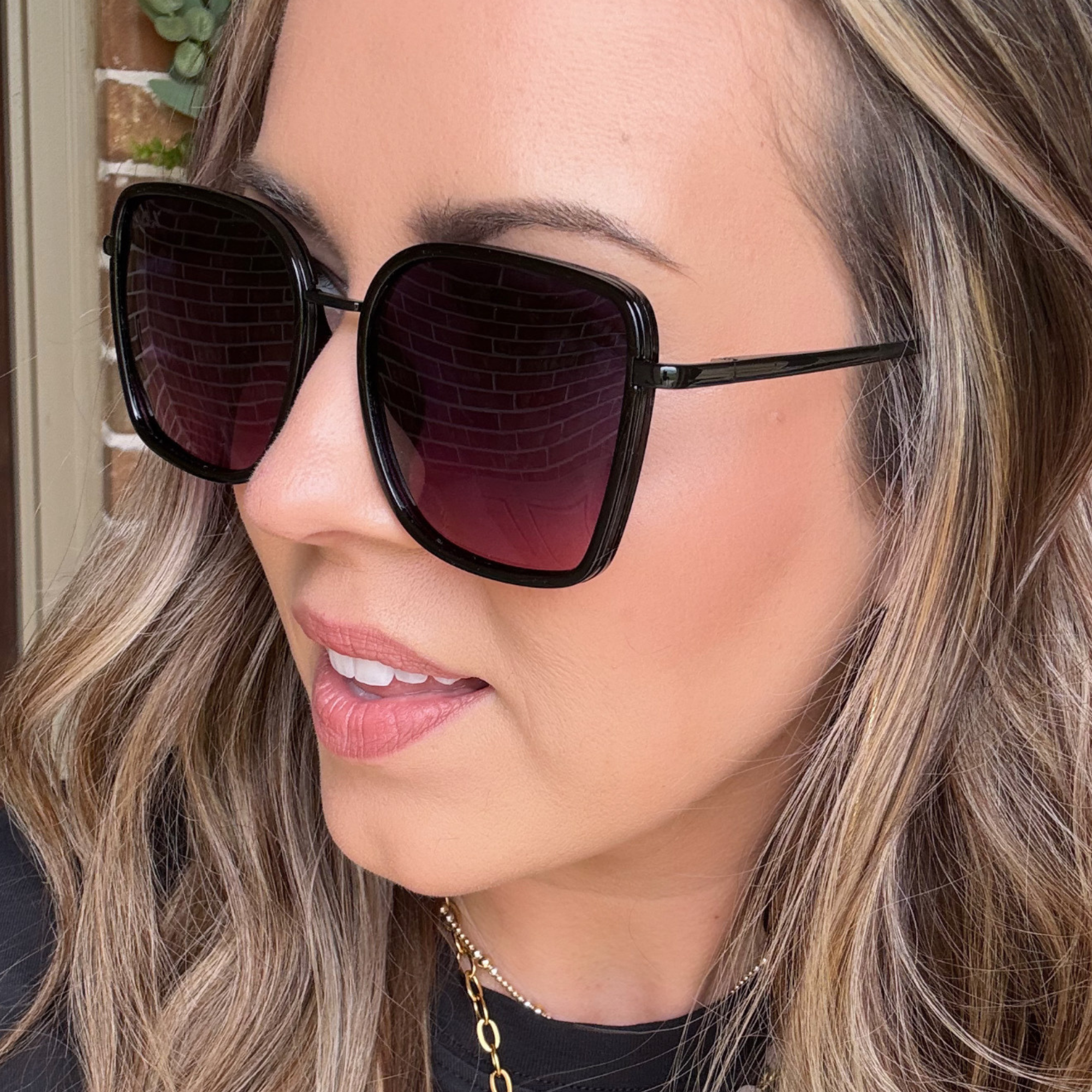 Close-up of a person wearing black sunglasses with a blurred background