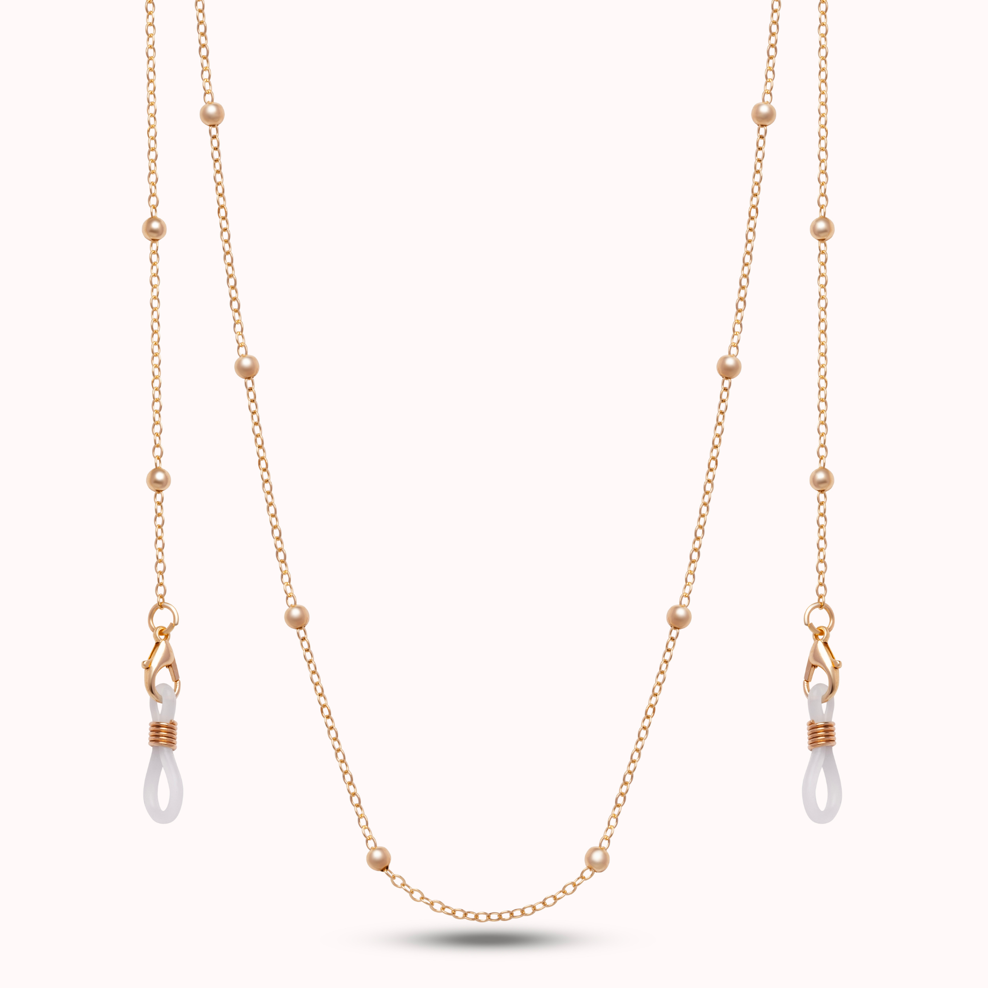 Gold chain with pearl drops on a white background