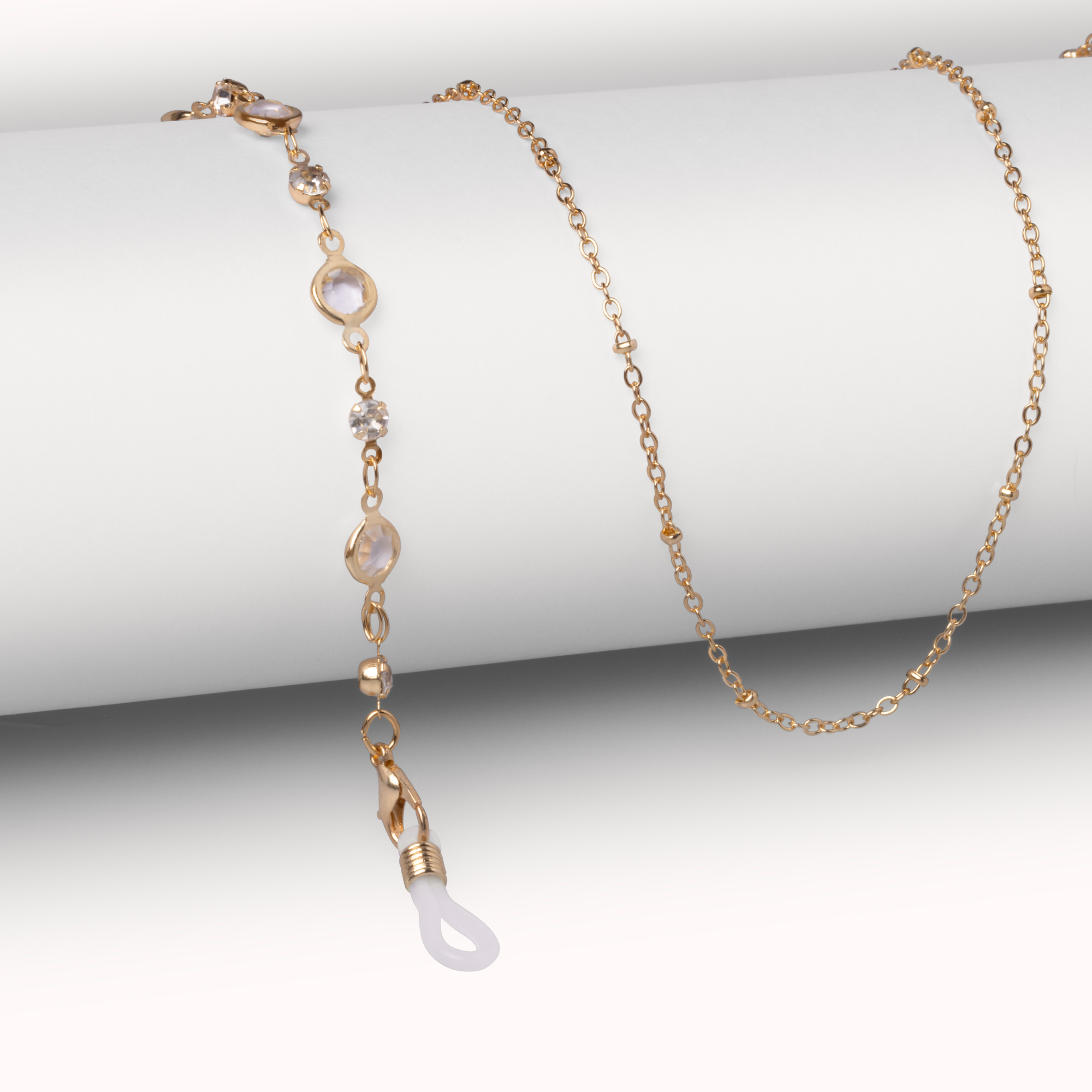 Gold necklace with white pendant on a white background