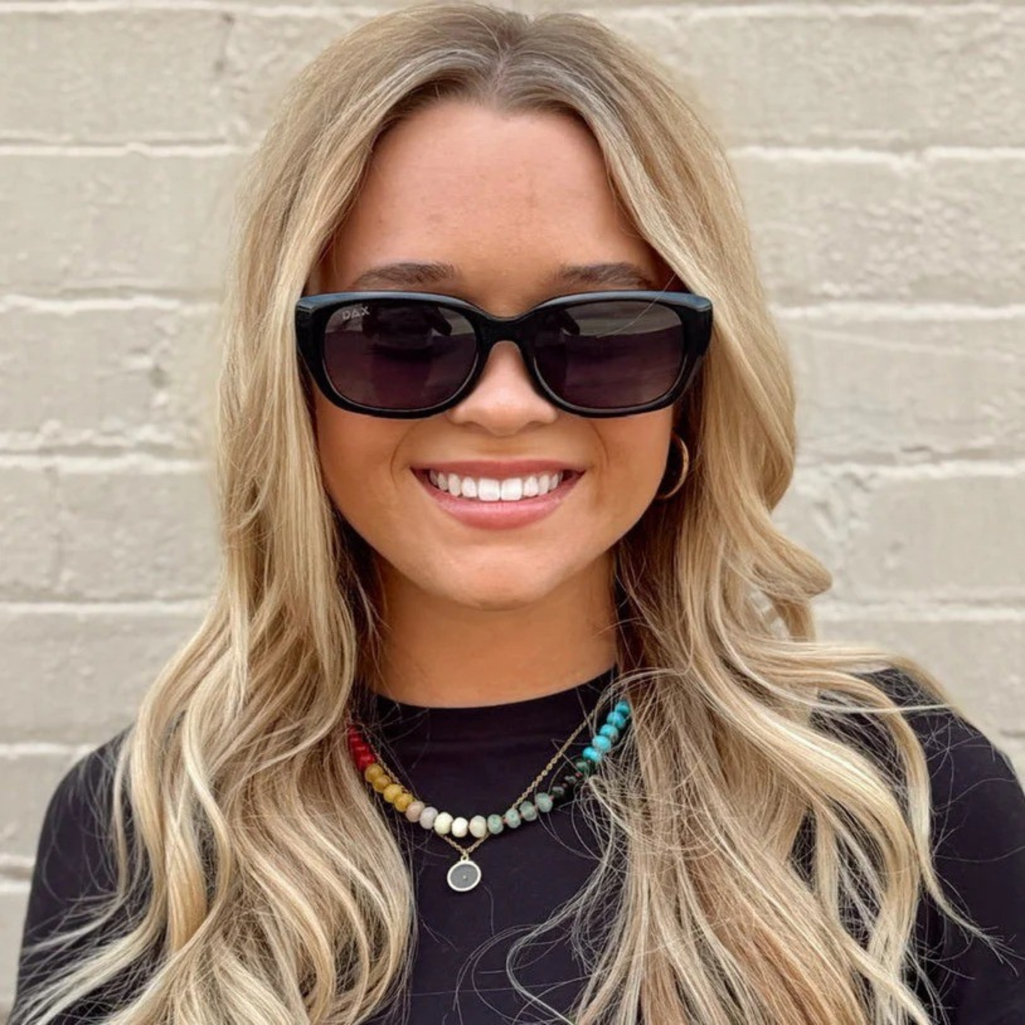 Woman wearing sunglasses with a neutral background