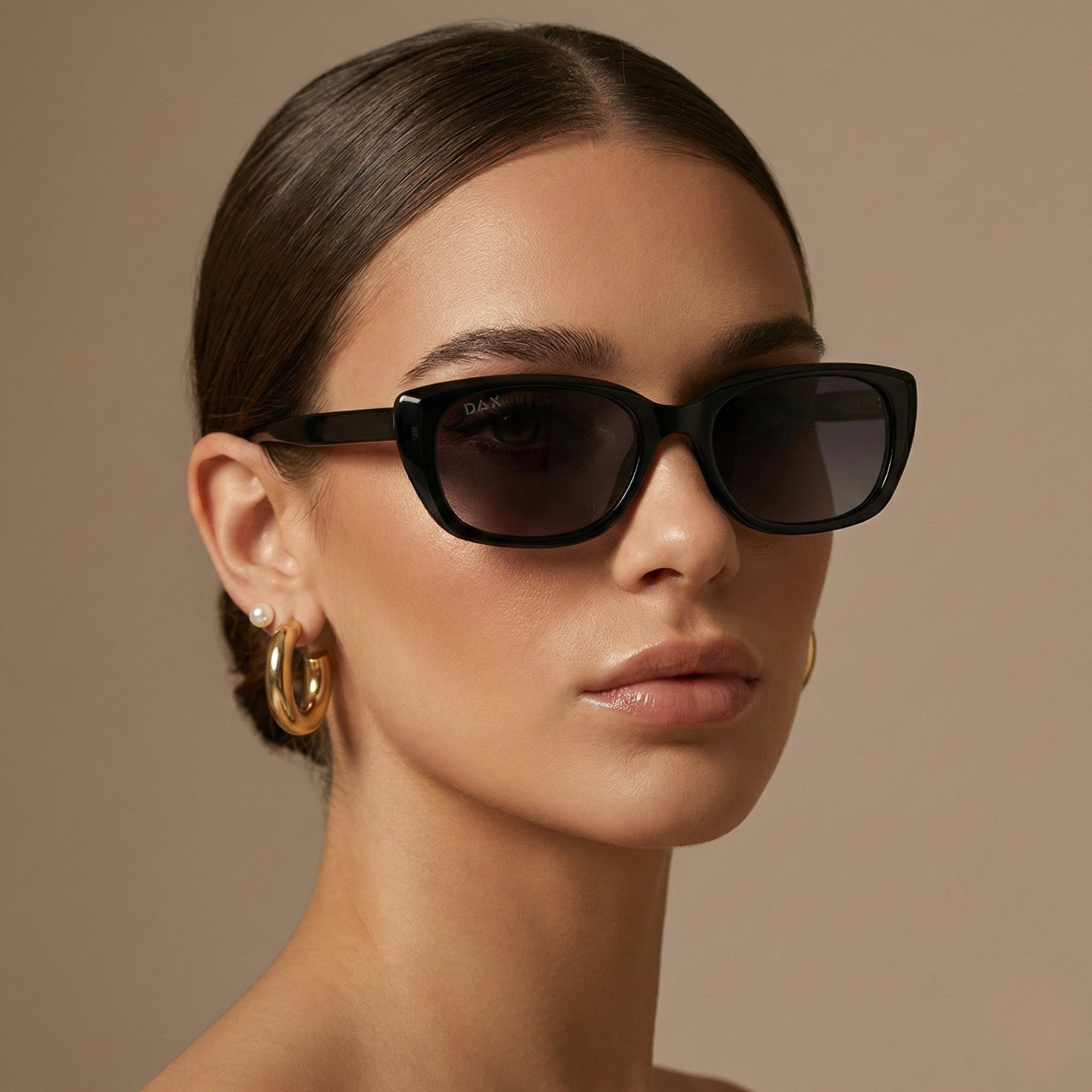 Woman wearing black sunglasses with a neutral background