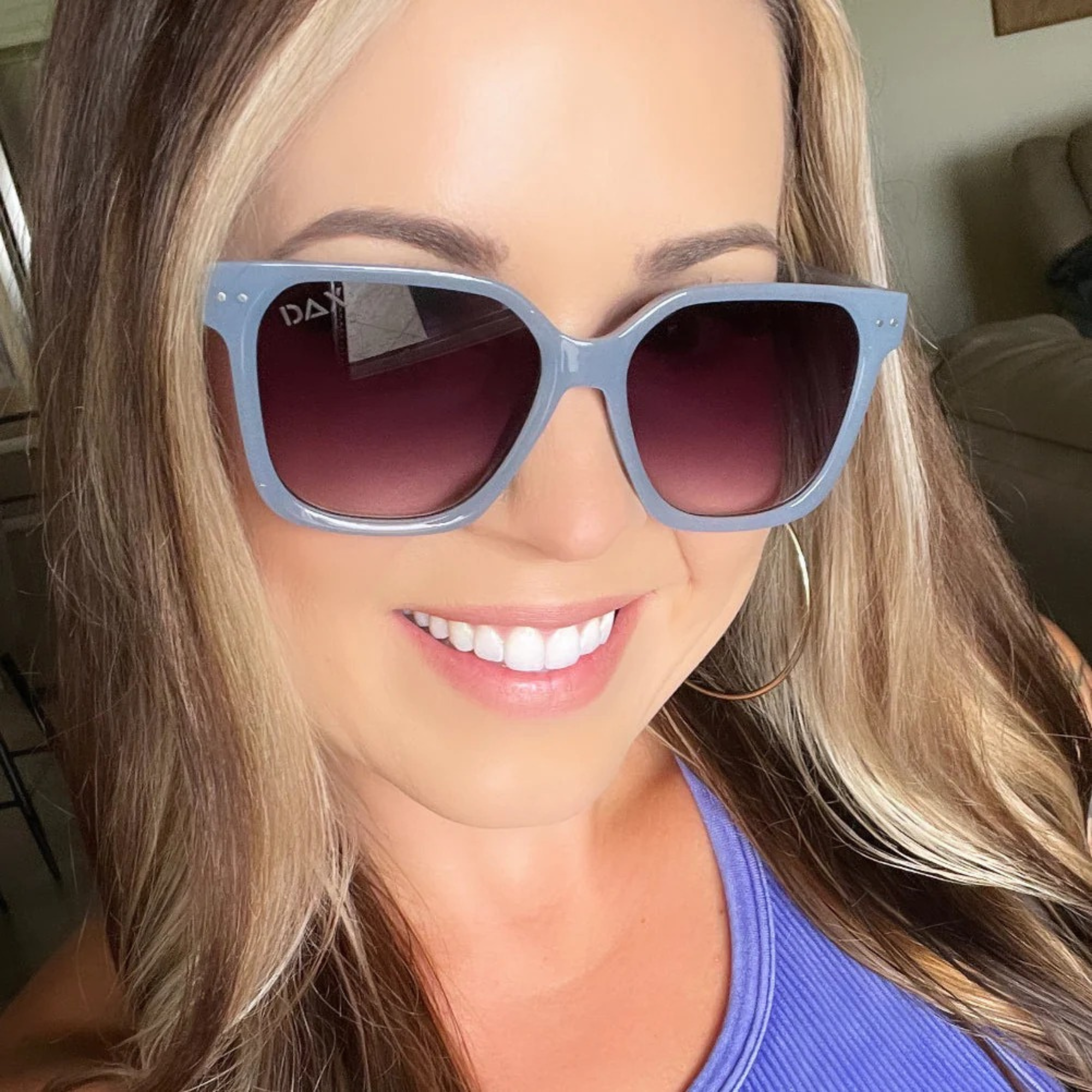 Woman wearing blue sunglasses with a blurred background