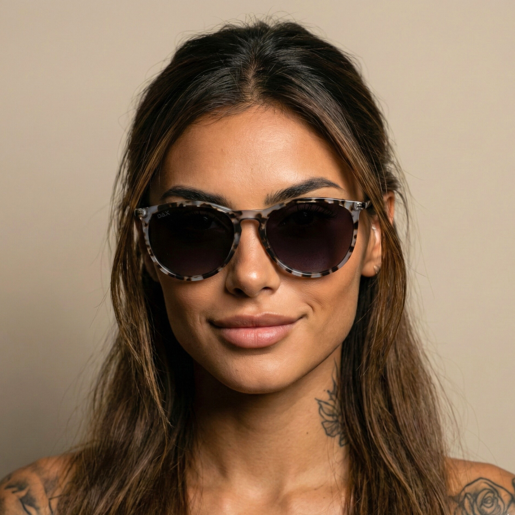 Woman wearing sunglasses with a neutral background