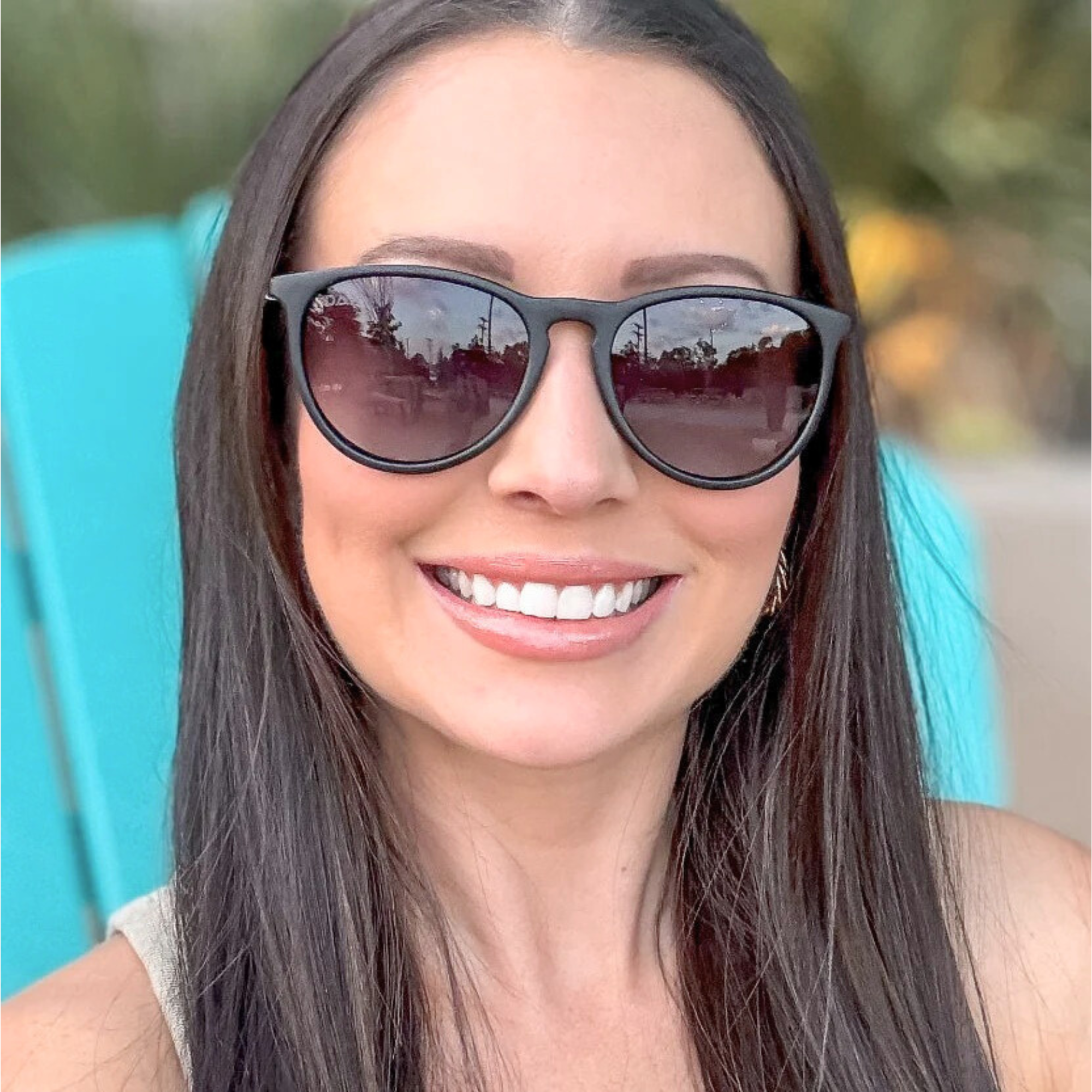 Woman wearing sunglasses with a blurred outdoor background