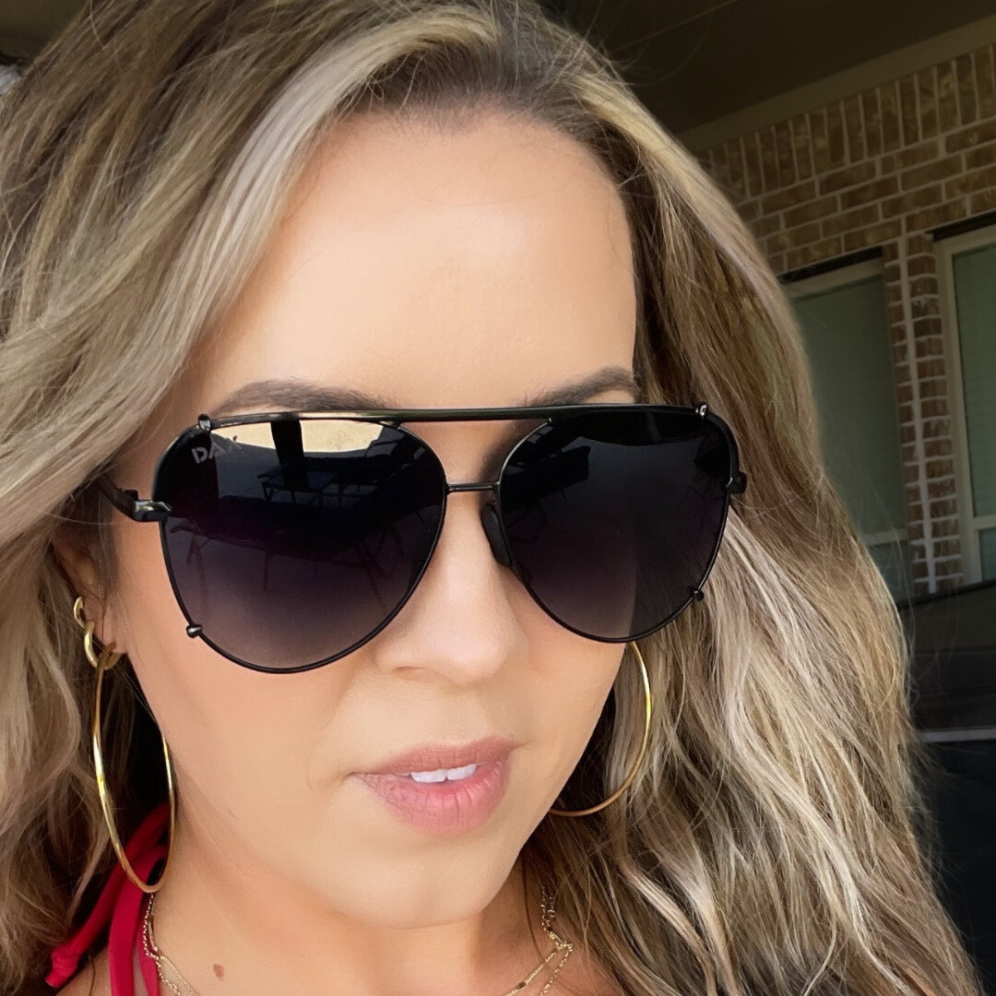 Woman wearing large sunglasses with a blurred background