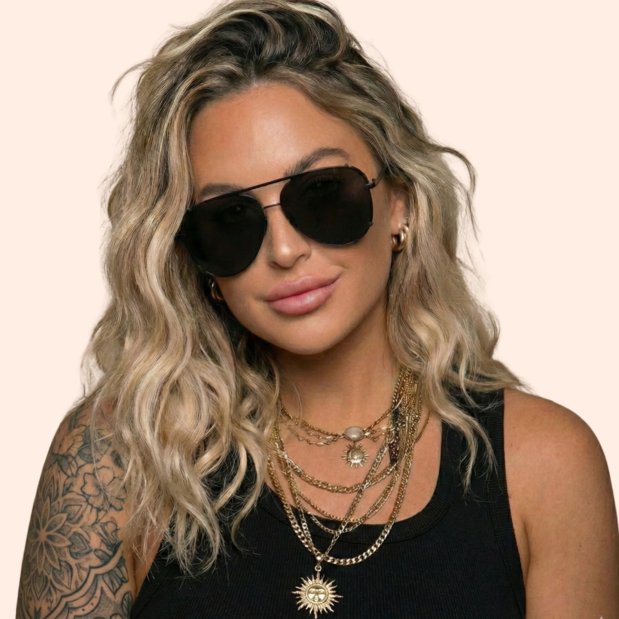 Woman wearing sunglasses and layered necklaces on a beige background