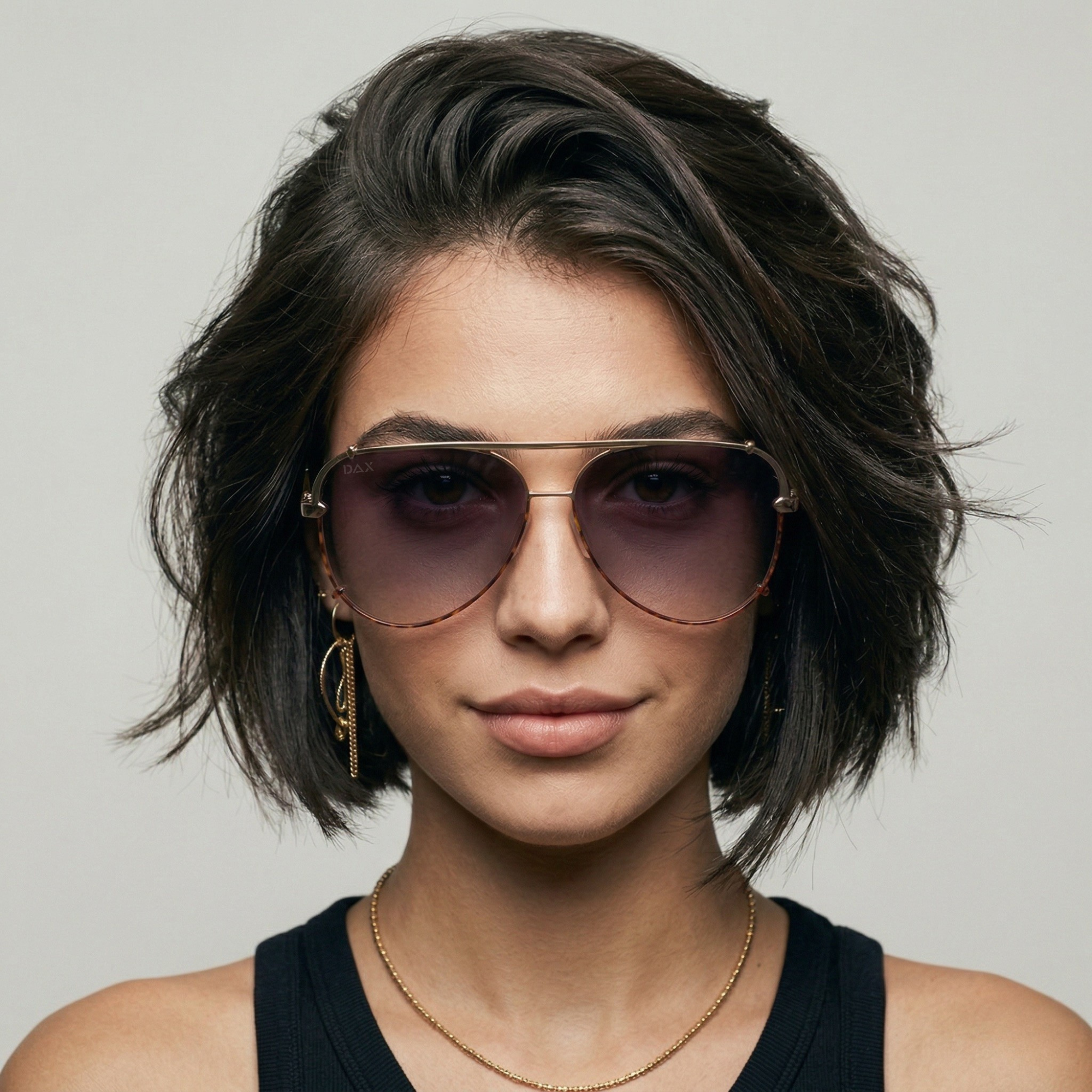 Woman wearing sunglasses with a neutral background