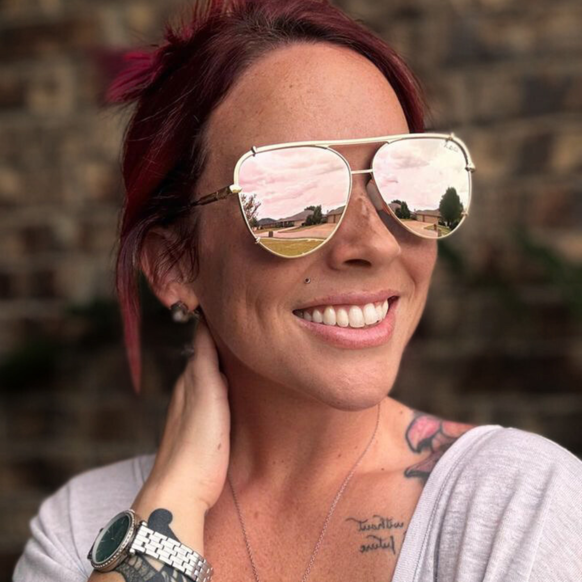 Woman wearing reflective sunglasses with a blurred natural background