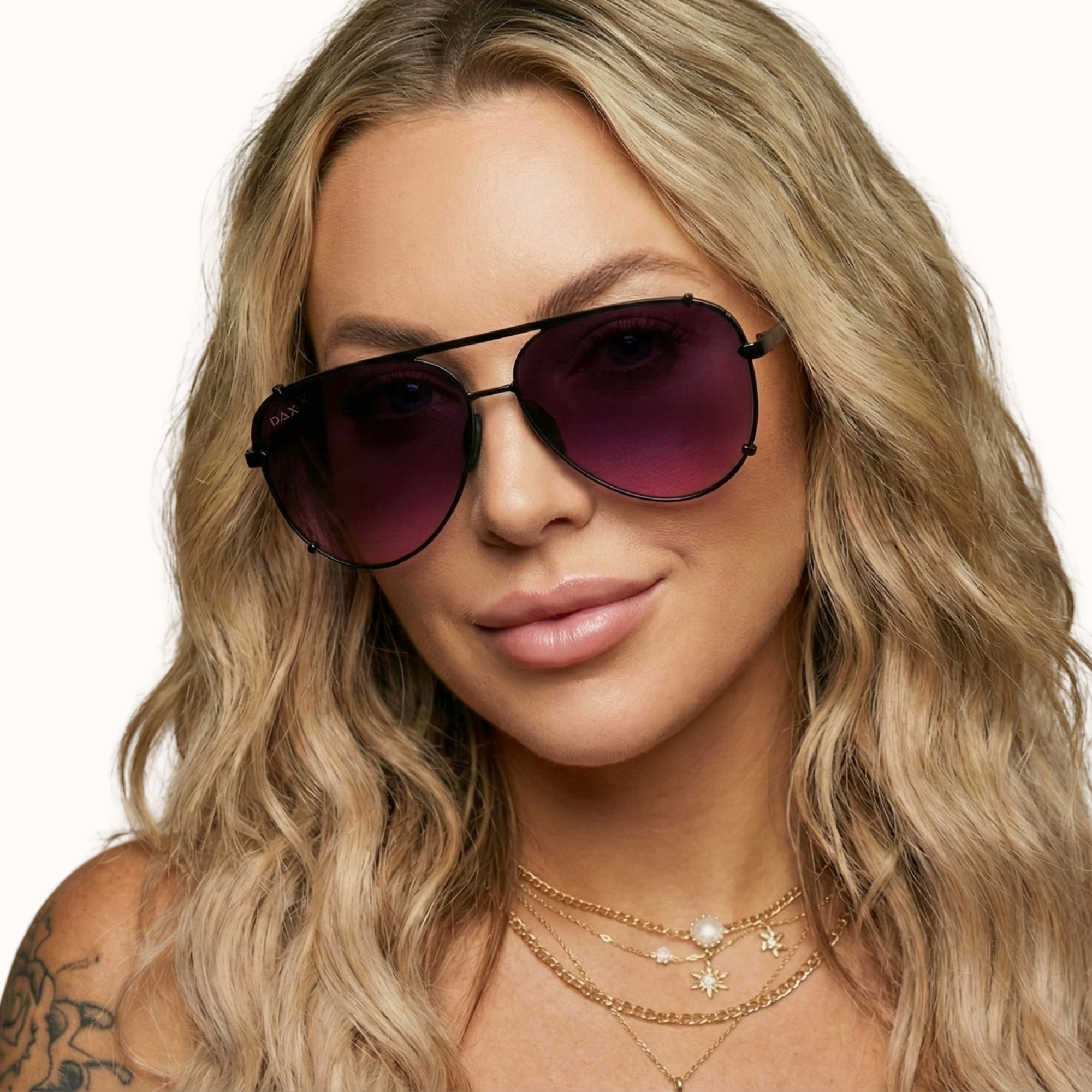 Woman wearing purple sunglasses with a plain background