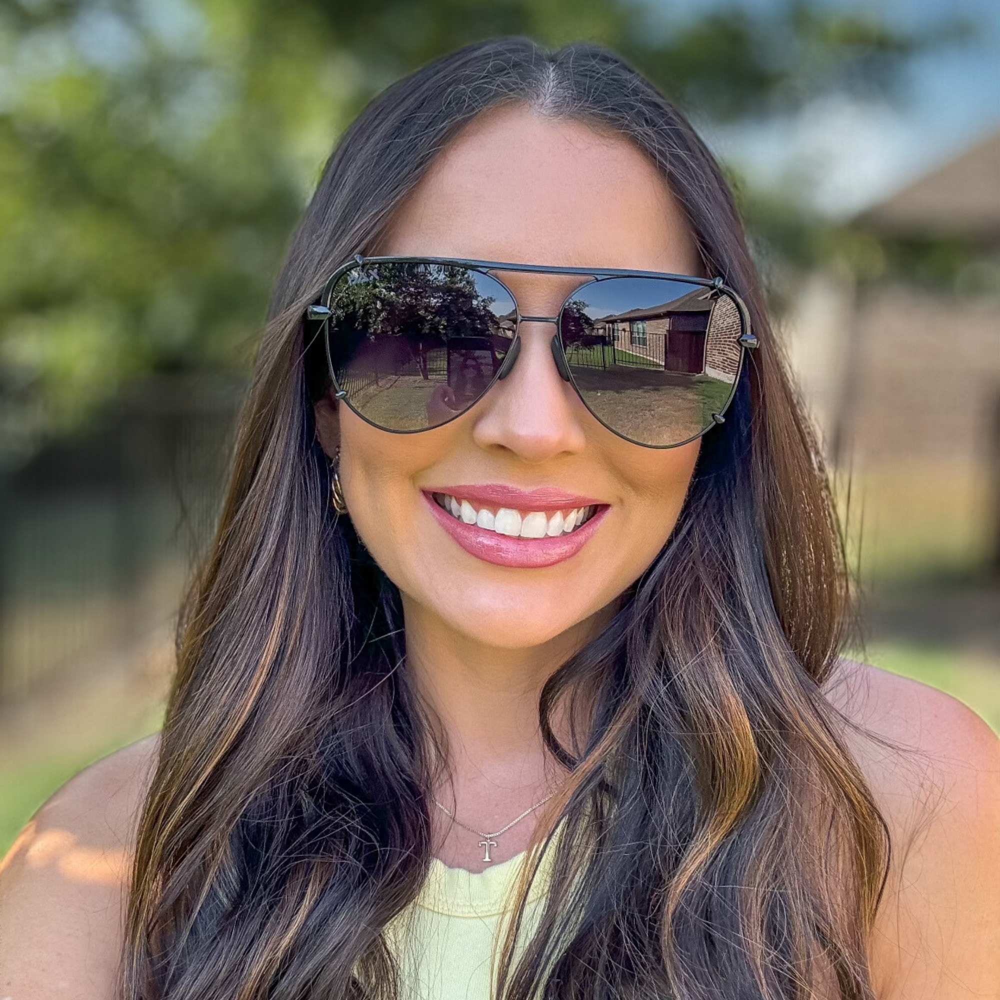 Woman wearing sunglasses with a blurred outdoor background