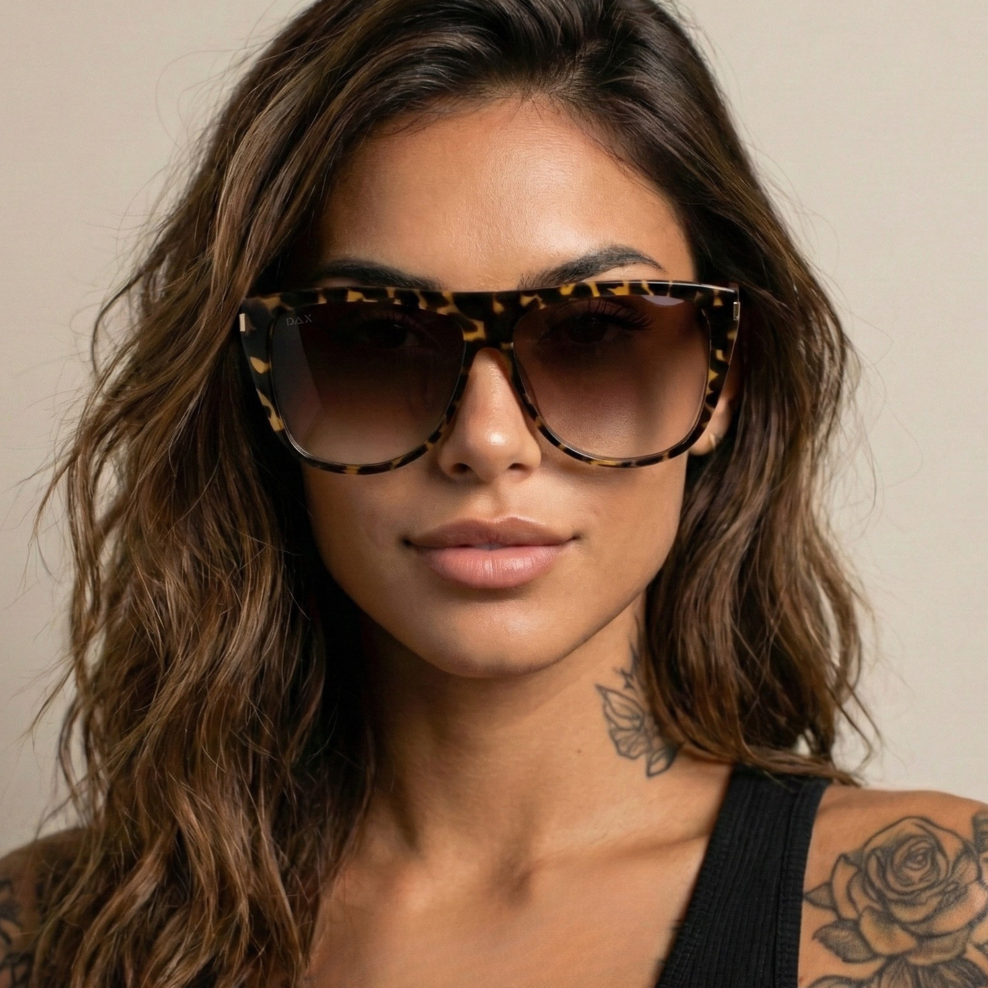 Woman wearing leopard print sunglasses with a neutral background
