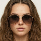 Close-up of a person wearing sunglasses with a neutral background