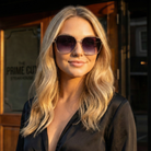 Woman wearing sunglasses with a blurred background of a restaurant entrance