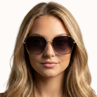 Woman wearing sunglasses with a plain background