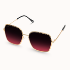 Sunglasses with gold frame and red gradient lenses on a white background