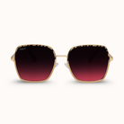 Gold-framed sunglasses with red gradient lenses on a white background