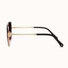 Sunglasses with gold frame and black arms on a white background