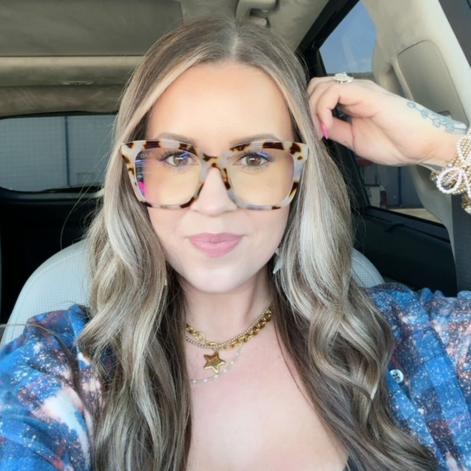 Woman wearing tortoiseshell sunglasses inside a car