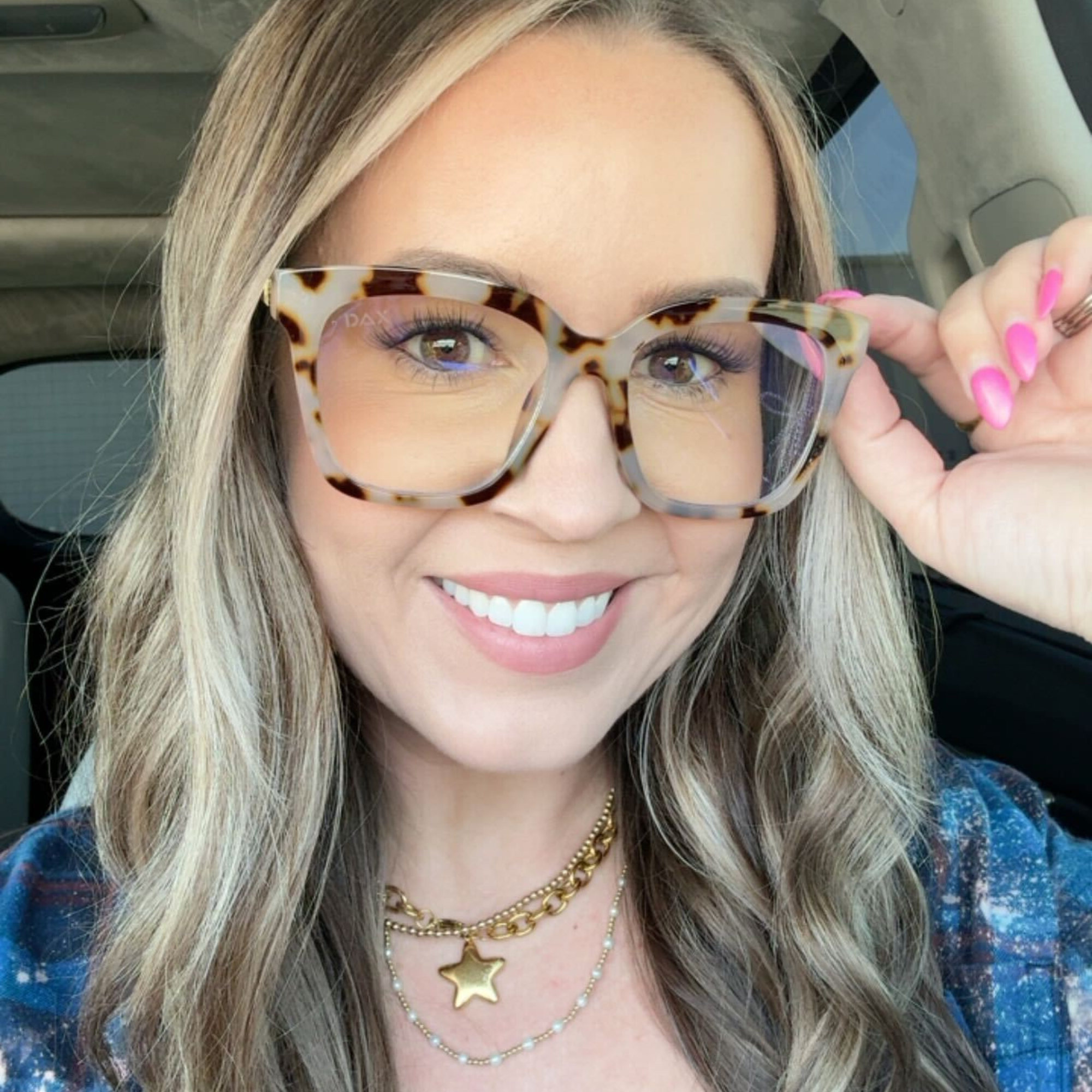 Woman wearing leopard print glasses inside a vehicle