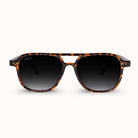 A pair of DAX brand sunglasses with a classic aviator-style frame in a brown and black tortoiseshell pattern, featuring dark gradient lenses, shown against a plain off-white background.