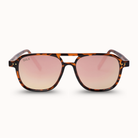 A pair of DAX brand sunglasses with a classic brown and black tortoiseshell frame and pink gradient lenses, shown against a clean off-white background.