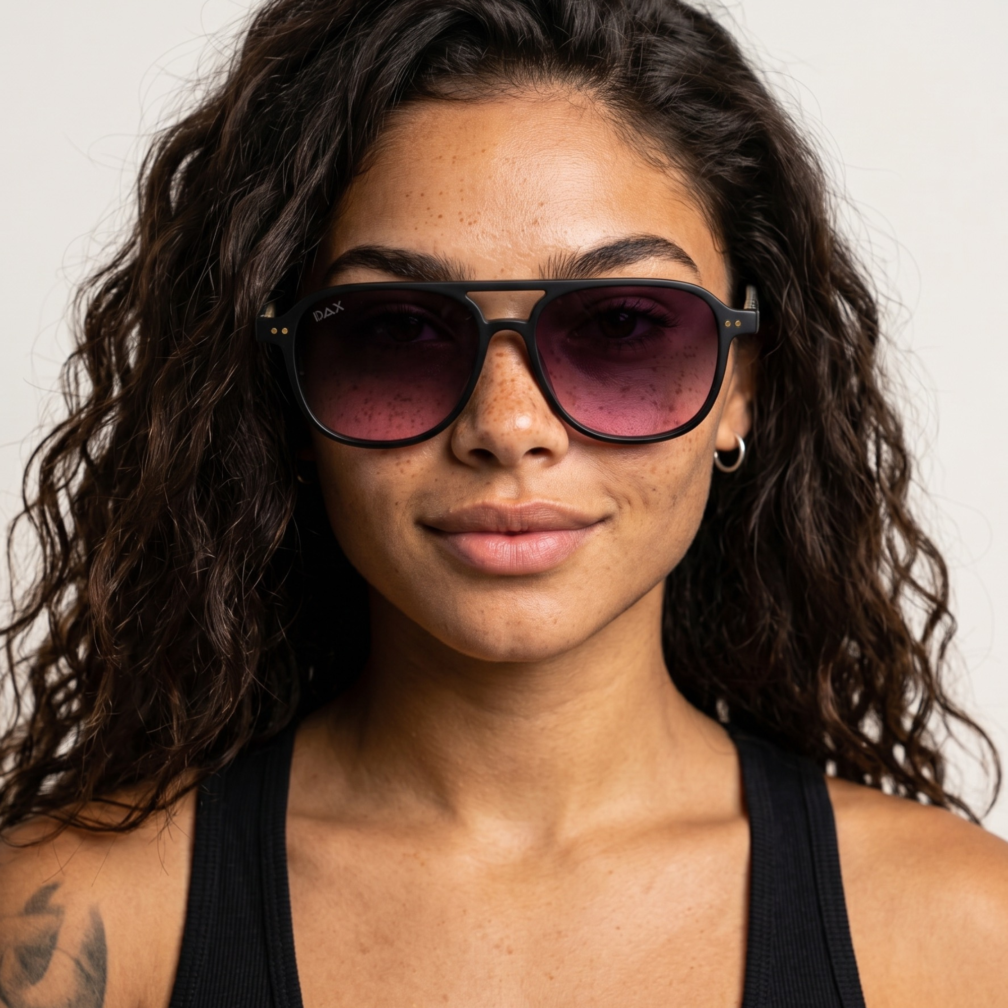 Woman wearing sunglasses with a neutral background