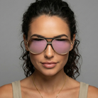 Woman wearing large sunglasses with a neutral background