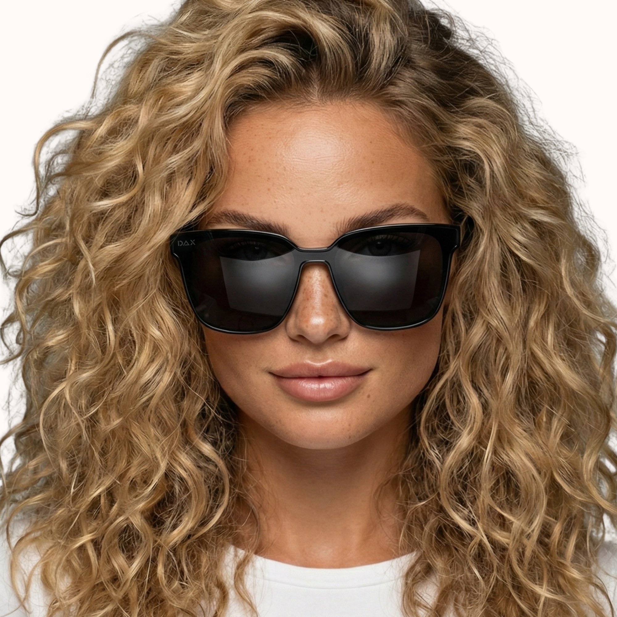 Woman wearing black sunglasses with curly blonde hair on a white background