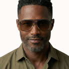 Man wearing sunglasses and a green shirt on a white background