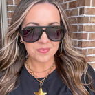 Woman wearing sunglasses with a brick wall background